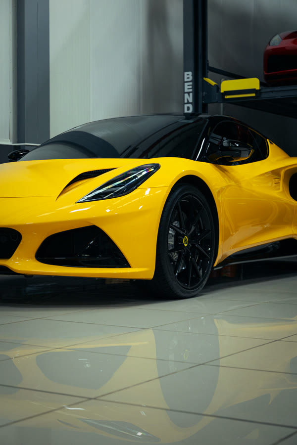 Lotus Emira amarillo de perfil en un showroom