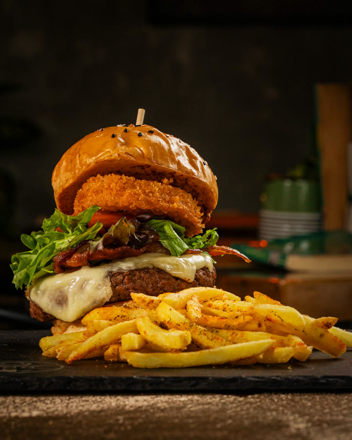 Hamburguesa con papas fritas sobre tabla de madera